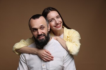 Portrait of happy daughter and father on brown background