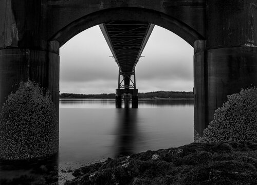 Concrete piers covered in barnacles underneath a bridge, Maine