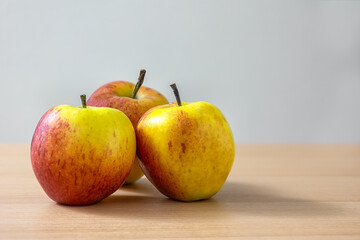 Still life of ripe apples on a table  with a grey background