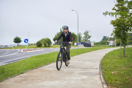 Man commuting on electric bicycle through suburban path
