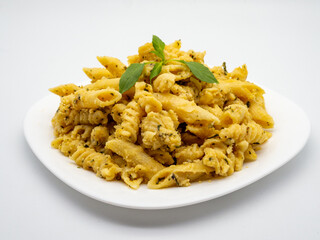 mix of penne quatro formaggi garnished with basil leaf on top on white plate