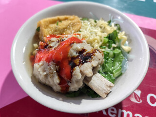 Rib meatball food is served in white bowls, equipped with various toppings, looks delicious and delicious, at roadside stalls.	