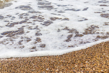 Beautiful texture of coarse beach sand. Beach-themed background image. Wet beach sand of large fraction.