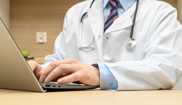 doctor working on computer, doctor in white medical coat