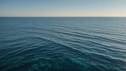 Obraz premium Calm ocean waves gently roll under a bright morning sky, filled with soft light and a peaceful horizon.