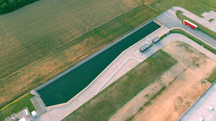 Drone view of industrial facility with warehouse and parking area