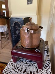 A copper pot sits on a red stand