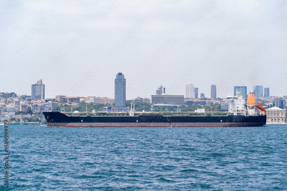 Poster cargo ship navigating the bosphorus with a modern skyline in the background during a clear day