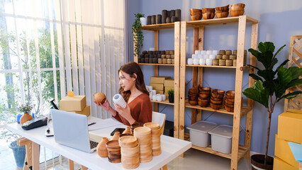 Small business owner live streams while showcasing handcrafted ceramic and wooden vases for online sale, highlighting artisan craftsmanship, home decor, and digital marketing in a cozy workspace.