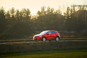 Fototapeta na wymiar Car on scenic rural road in evening glow