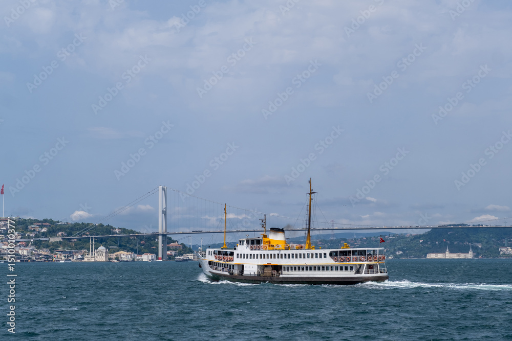 Aufkleber ferry navigating the bosphorus strait under an iconic bridge with city skyline in the background