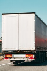Cargo truck on clear blue sky highway.