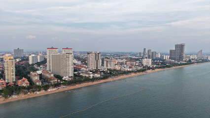 Modern buildings rising along the pattaya coastline create a stunning cityscape against the ocean backdrop as twilight approaches, blending urban development with natural beauty