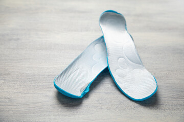 Shoe insole on the white wooden background.