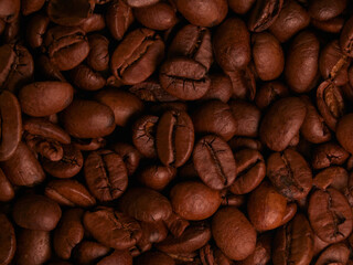 A close-up shot of roasted coffee beans, highlighting their rich texture and deep brown color, perfect for food and beverage themes