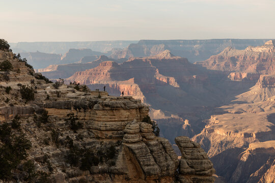 A breathtaking panoramic view of the Grand Canyon reveals its vast, layered rock formations and dramatic cliffs under a clear sky