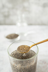 Chia Seeds Soaking in Water with Golden Spoon Showing Natural Gel Formation