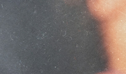 grainy colorful warm orange light leaks on black background with dust texture. abstract damaged...