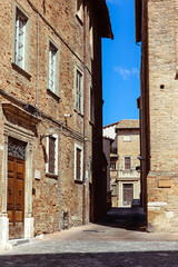 Narrow, brick-lined alleyways of Urbino, Italy, where medieval architecture and cobblestone streets create a timeless atmosphere. Urbino, Marche region, Italy