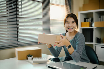 Cheerful small business owner showing a cardboard parcel, ready for delivery