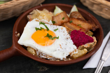 Breakfast of scrambled eggs with fried bacon and potatoes