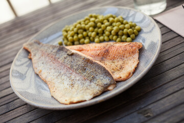 Delicious baked trout fillet with green peas