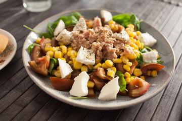 Fish salad with canned tuna and corn, tomatoes and arugula