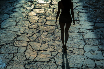 Woman walking on cracked pavement silhouette