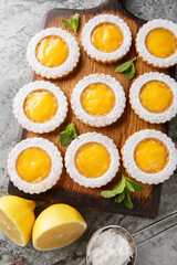 Cookies combine two layers of buttery Shortbread Cookies and a homemade tangy Lemon Curd filling closeup on wooden board on the table. Vertical top view from above