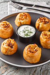 Knish or knysh is a traditional food of Eastern European consists of a filling covered with dough that is baked closeup on the plate on the table. Vertical