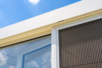 Véranda moderne lumineuse avec baies vitrées et mobilier contemporain, ouverte sur un jardin verdoyant.