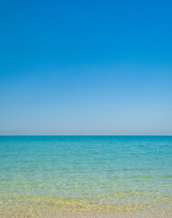 Photography serene tropical beach scene with clear turquoise sea water gentle waves and bright blue sky. Image captures peaceful and minimalist view sea ideal for backgrounds travel concepts vacation