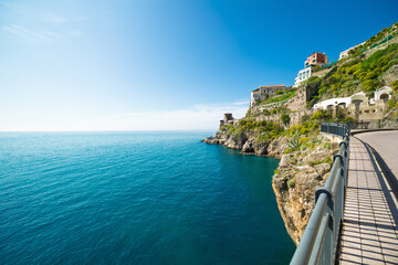 Amalfi Coast picturesque landscape, bright summer day. Coastal road along steep cliffs, deep blue Tyrrhenian Sea. Iconic travel destination in Campania region, Italy.