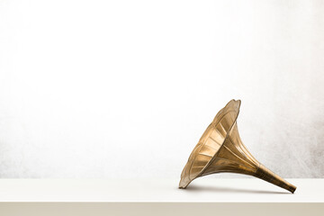Vintage brass horn on white table.