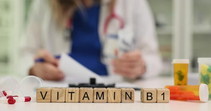 Text Vitamin B1 of wooden cubes on doctor desk. Woman physician prescribes essential nutrient for overall health and wellness in healthcare facility