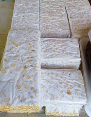 several rectangular blocks of fresh tempeh, a traditional indonesian fermented soybean cake, displayed in plastic packaging.