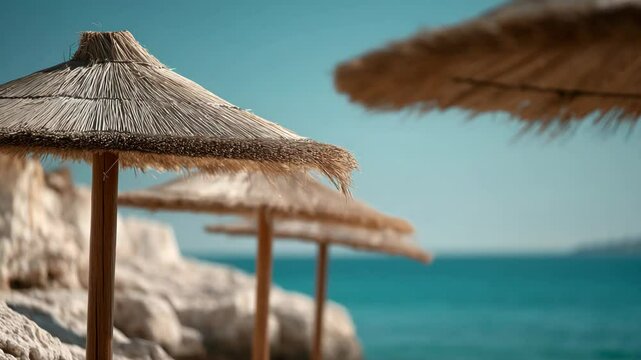 Beach umbrellas on rocky shore with tranquil blue sea background  