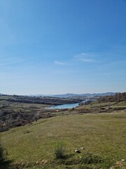 Scenic View Over Farka Lake Hills. A calm and scenic view over Farka Lake in Tirana, surrounded by olive trees, hills, and peaceful countryside atmosphere.
Farka Lake view Tirana Albania.