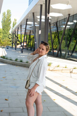 Pretty young girl wearing shorts and a white shirt in the summer park