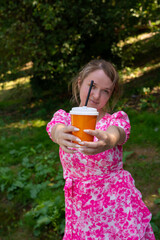 Pretty blonde girl wearing pink and white dress in the park
