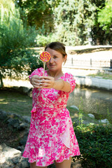 Pretty blonde girl wearing pink and white dress in the park