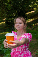 Pretty blonde girl wearing pink and white dress in the park