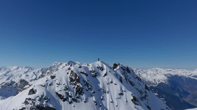 A professional skier hikes up a steep ridge in Verbier, then drops into an epic freeride descent. Pure adventure skiing in deep snow, dramatic terrain, and breathtaking alpine scenery.