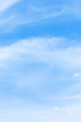 Blue sky background and white clouds soft focus, space in the middle, vertical shape.