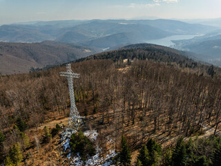Aerial drone view of beskid mountains in spring. Chrobacz Meadow peak in the Magurka Wilkowicka Group in the Little Beskids. Cross on a mountaintop in the Beskids..