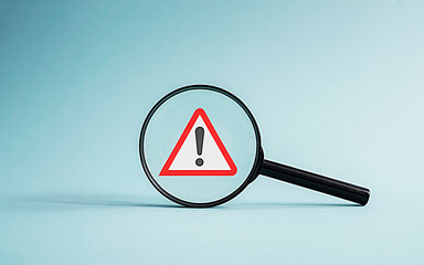 Warning triangle sign with danger and electricity symbols on road and white background
