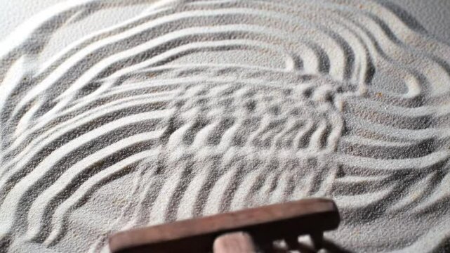 Zen garden rake making patterns in white sand