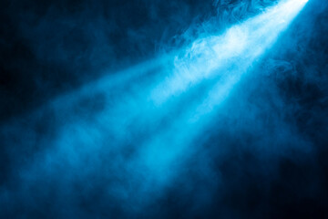 Blue spotlight beaming through smoky haze