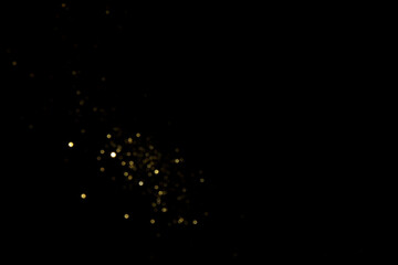 Golden blurred bokeh lights on black background. Glitter sparkle stars for celebrate. Overlay for your design