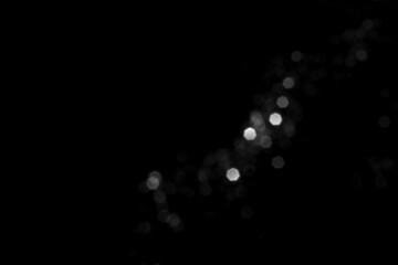 White gray blurred bokeh lights on black background. Glitter sparkle stars for celebrate. Overlay for your design